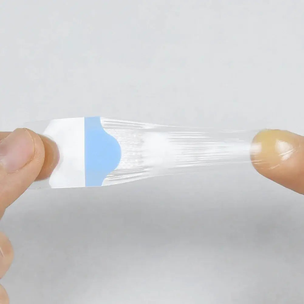 Transparent waterproof adhesive wound plaster being peeled from its white backing with a blue pull tab