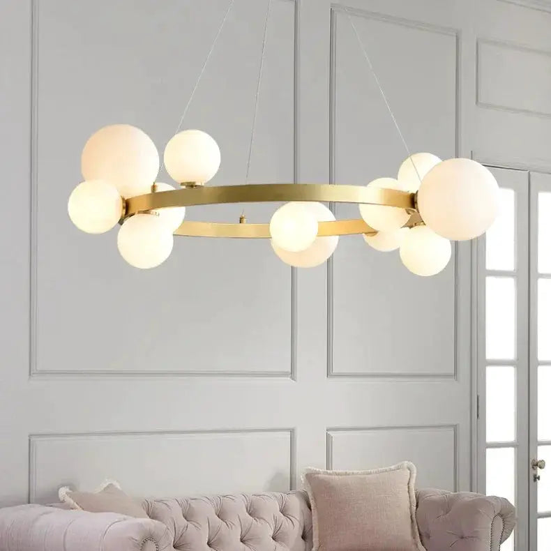 Gold ring chandelier with frosted glass globes by Simples Market for indoor living room lighting