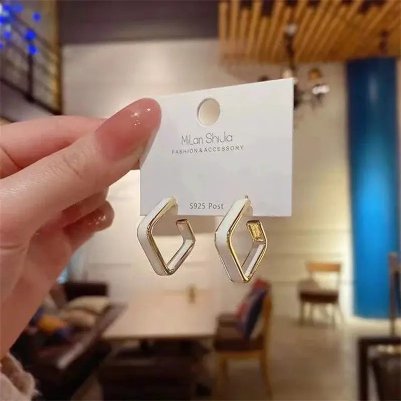 Geometric white enamel dangle earrings with gold-tone trim, pair