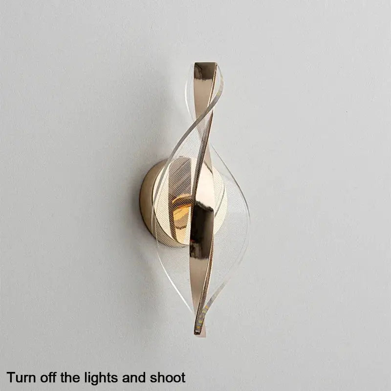 Nordic LED wall lamp with gold-tone metal ribbons and acrylic backplate for modern living rooms