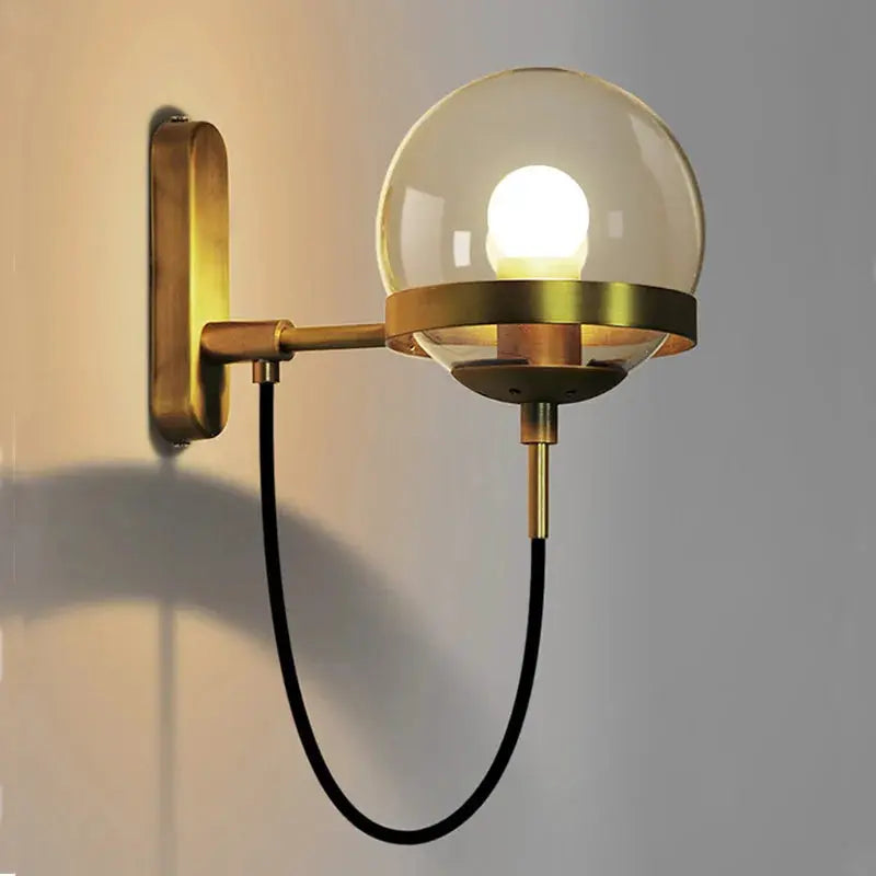 Modern glass ball wall lamp with brass finish and black cord, wall-mounted industrial bedside light for living room