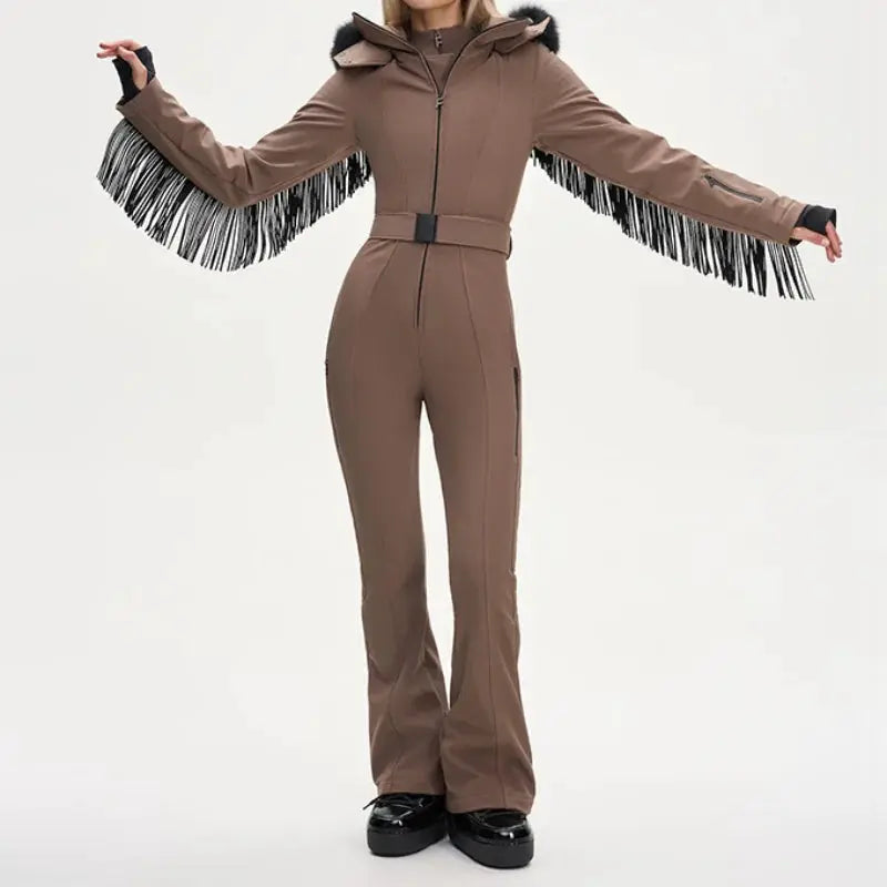 One-piece ski suit for women by Simples Market, brown with faux fur hood, tassel fringe sleeves, and belt.