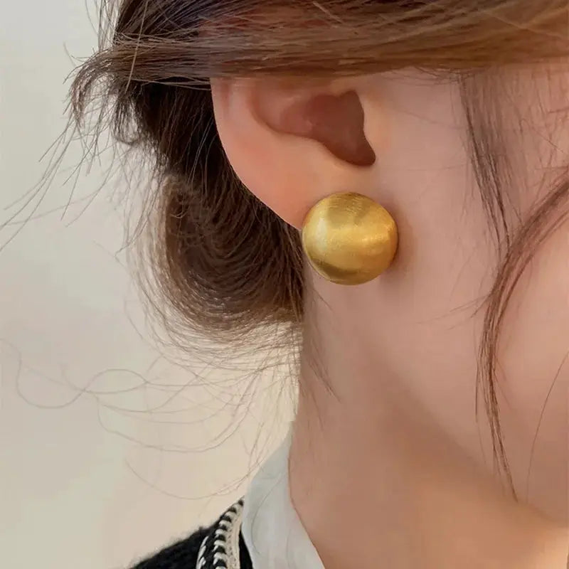 Gold-tone brushed metal round stud earring; simple design by Simples Market