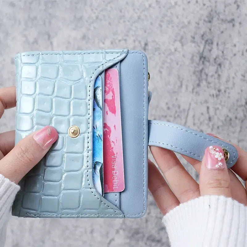Mini crocodile-print blue clutch wallet by Simples Market with card slots and wrist strap.