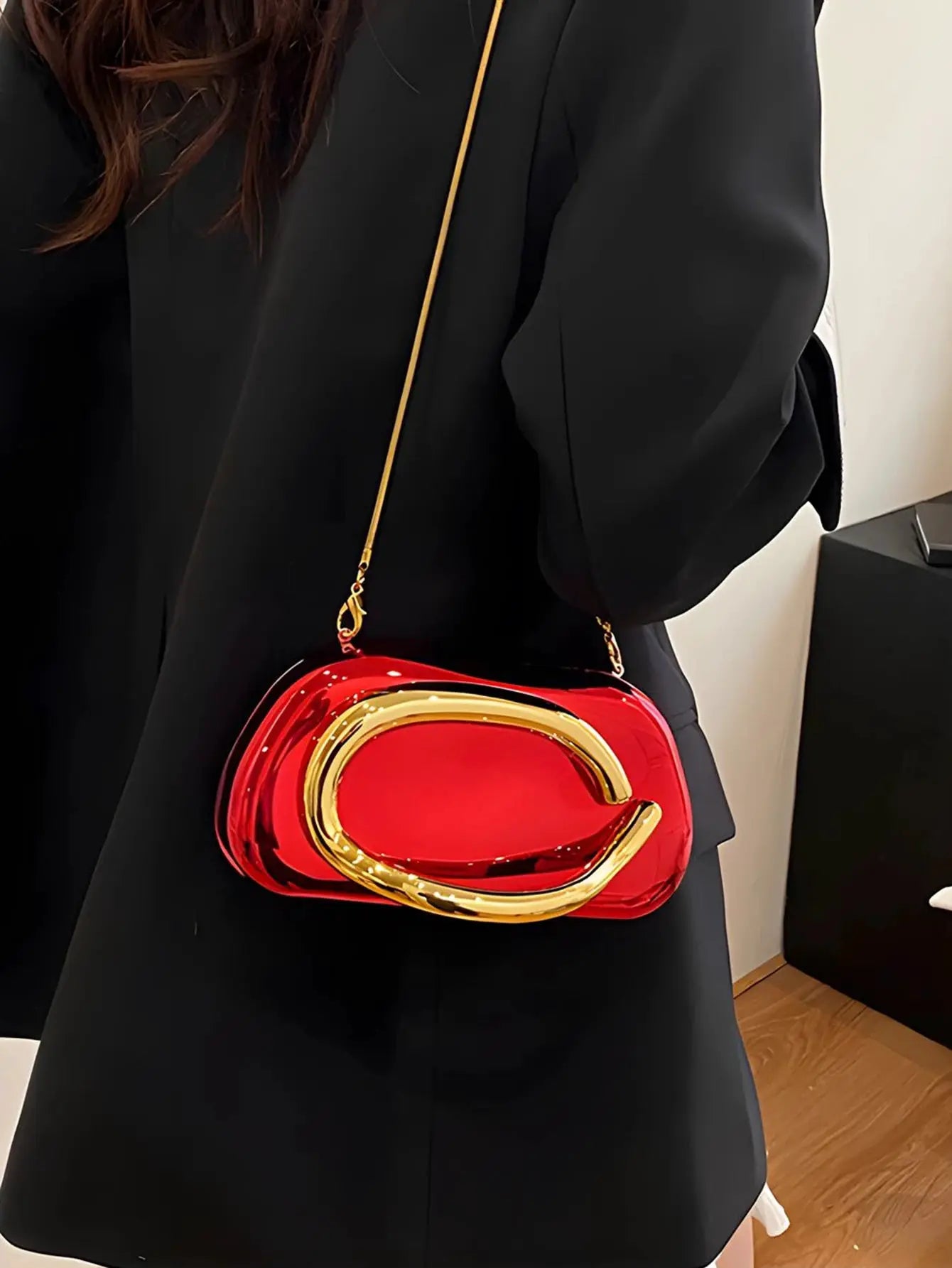 Red acrylic box crossbody bag with gold-tone frame and chain strap.