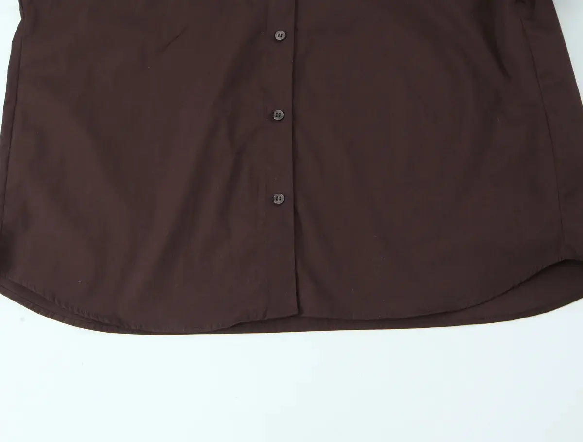 Brown women's button-down shirt with front buttons and curved hem, solid fabric.
