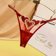 Red sheer thong with two heart appliques on the waistband and adjustable thin side straps