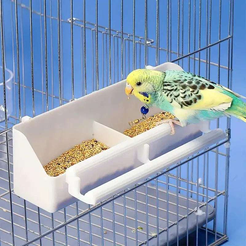 Double-grid stand bird feeding trough, white plastic, mounted on a metal cage for parrot seeds.