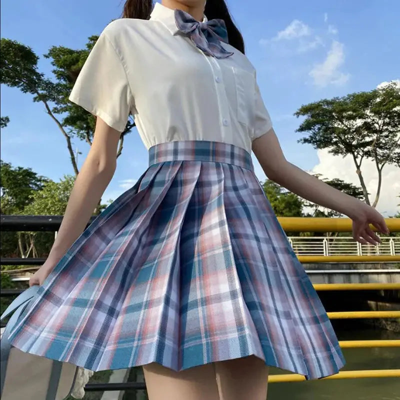 ZOKI plaid pleated high-waist skirt in blue and pink plaid, shown with a white blouse.
