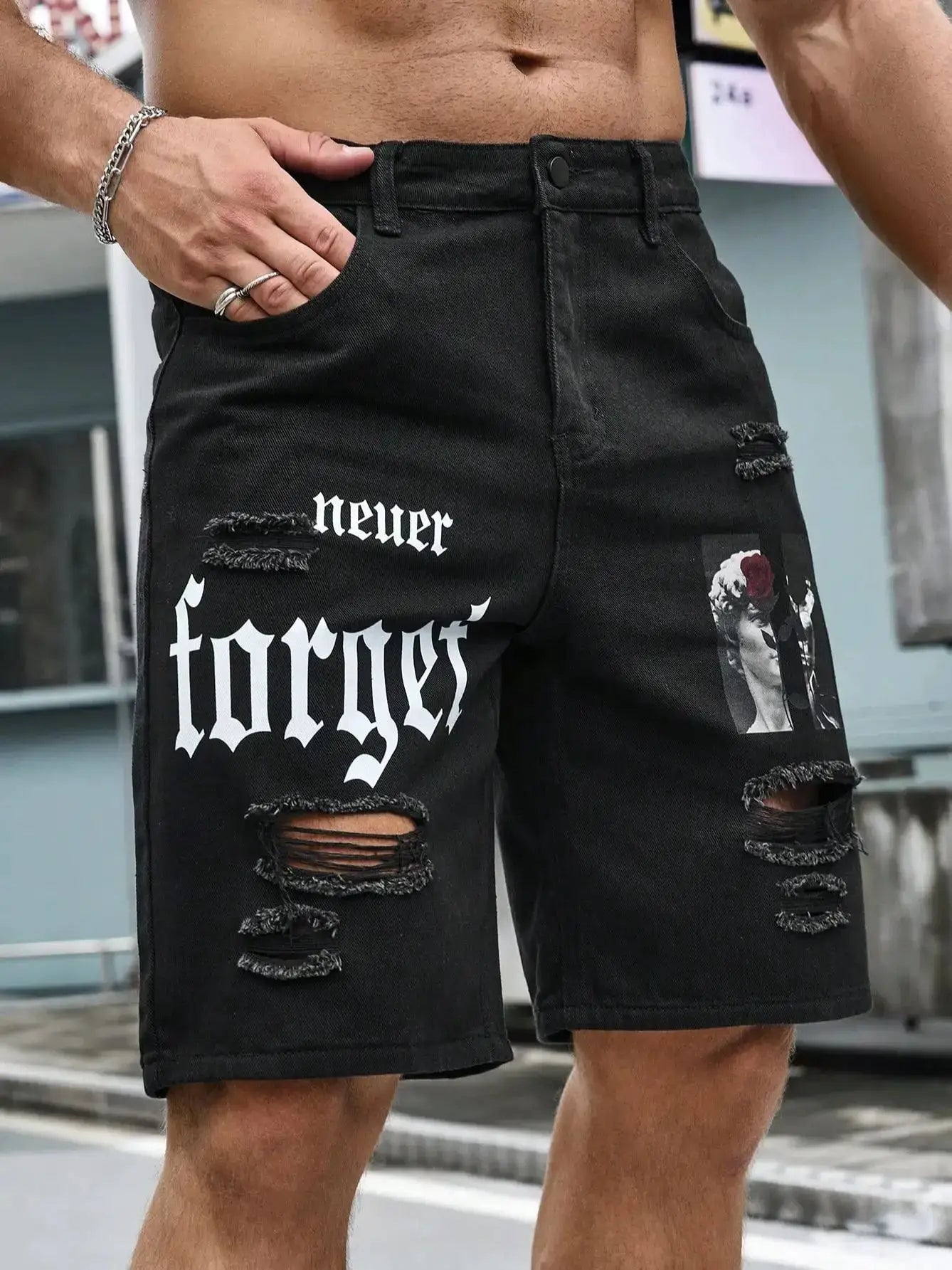 Men's black denim shorts with ripped knee holes, bold white gothic print and patch graphic