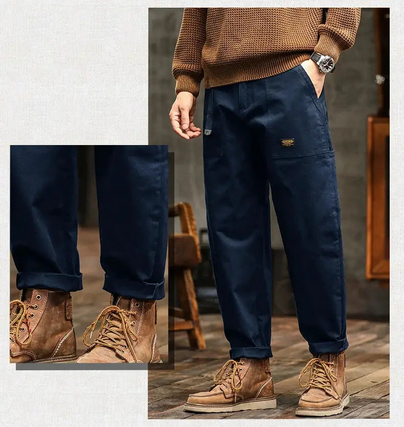HIQOR men's loose-profile navy blue cargo pants with rolled cuffs and brown boots.