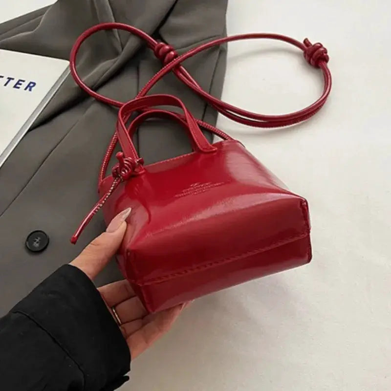 PU leather mini crossbody bag in red with glossy finish, top handles and long strap
