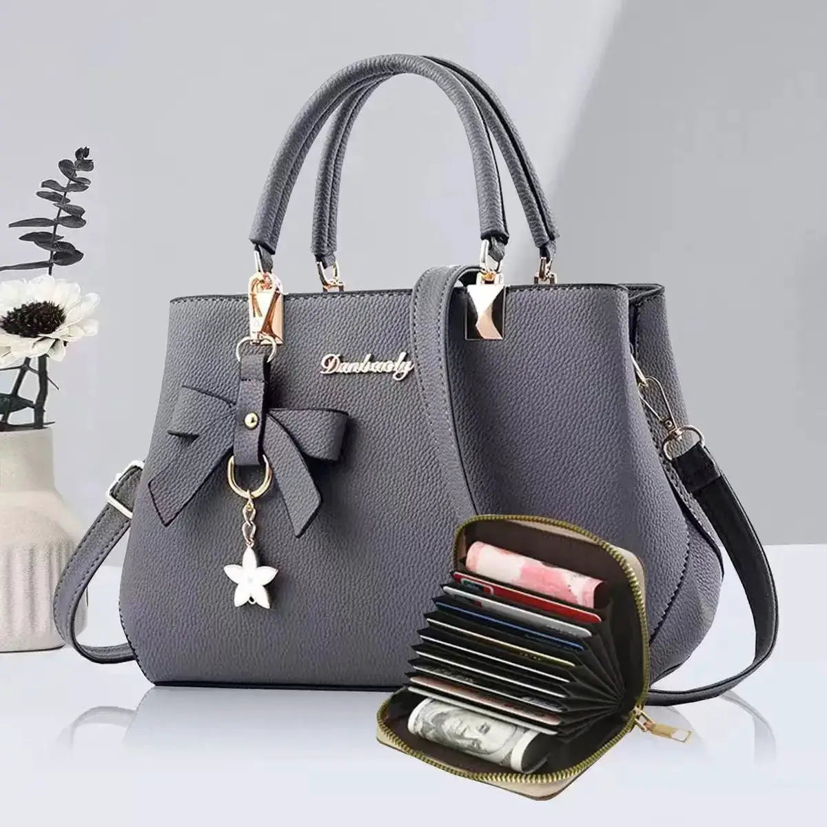 Simples Market gray bow handbag with top handles, detachable crossbody strap, and gold hardware