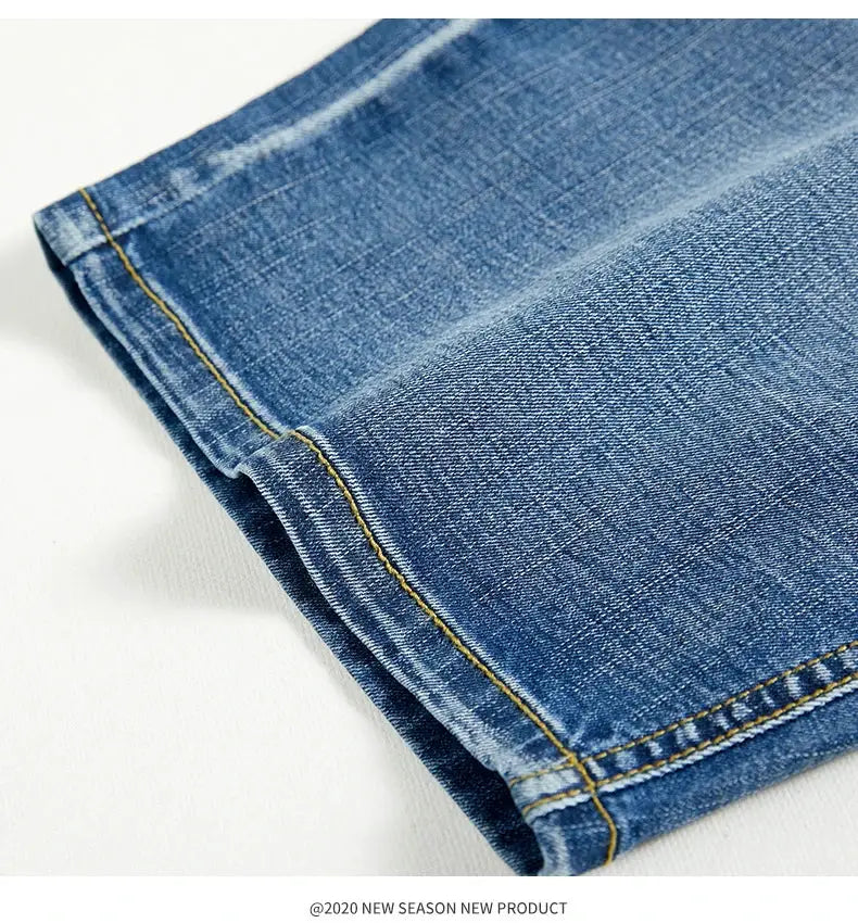 Blue denim shorts close-up with yellow contrast stitching and folded hem