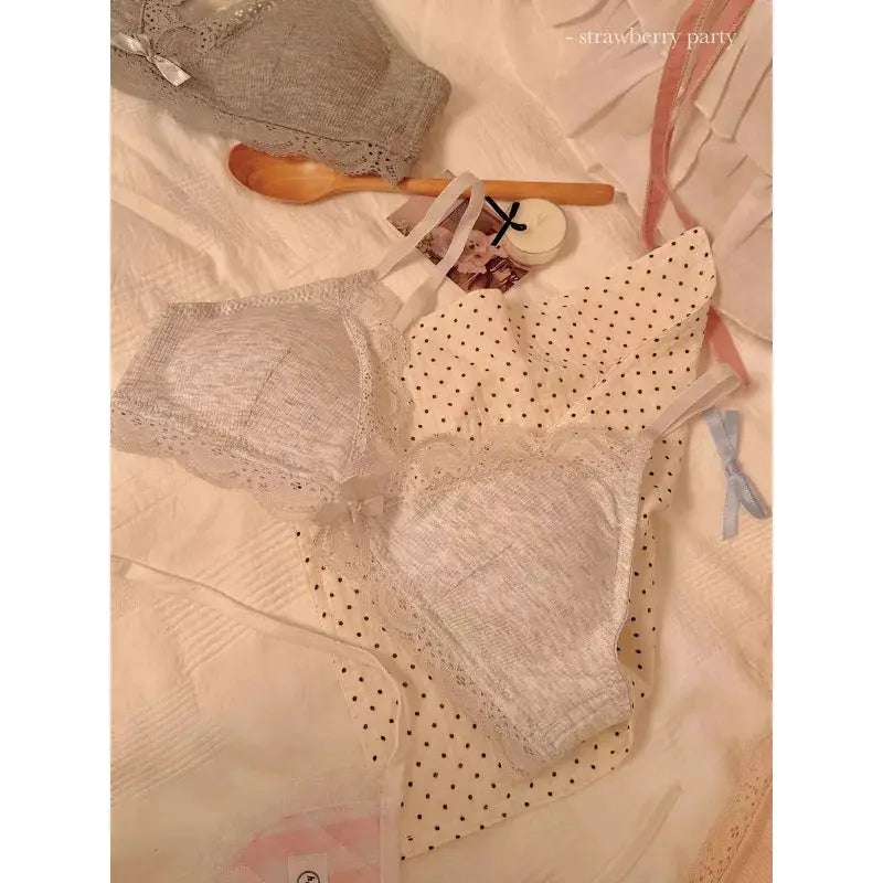 Three women's lace triangle-cup bras in gray, cream with polka dots, and light gray lace