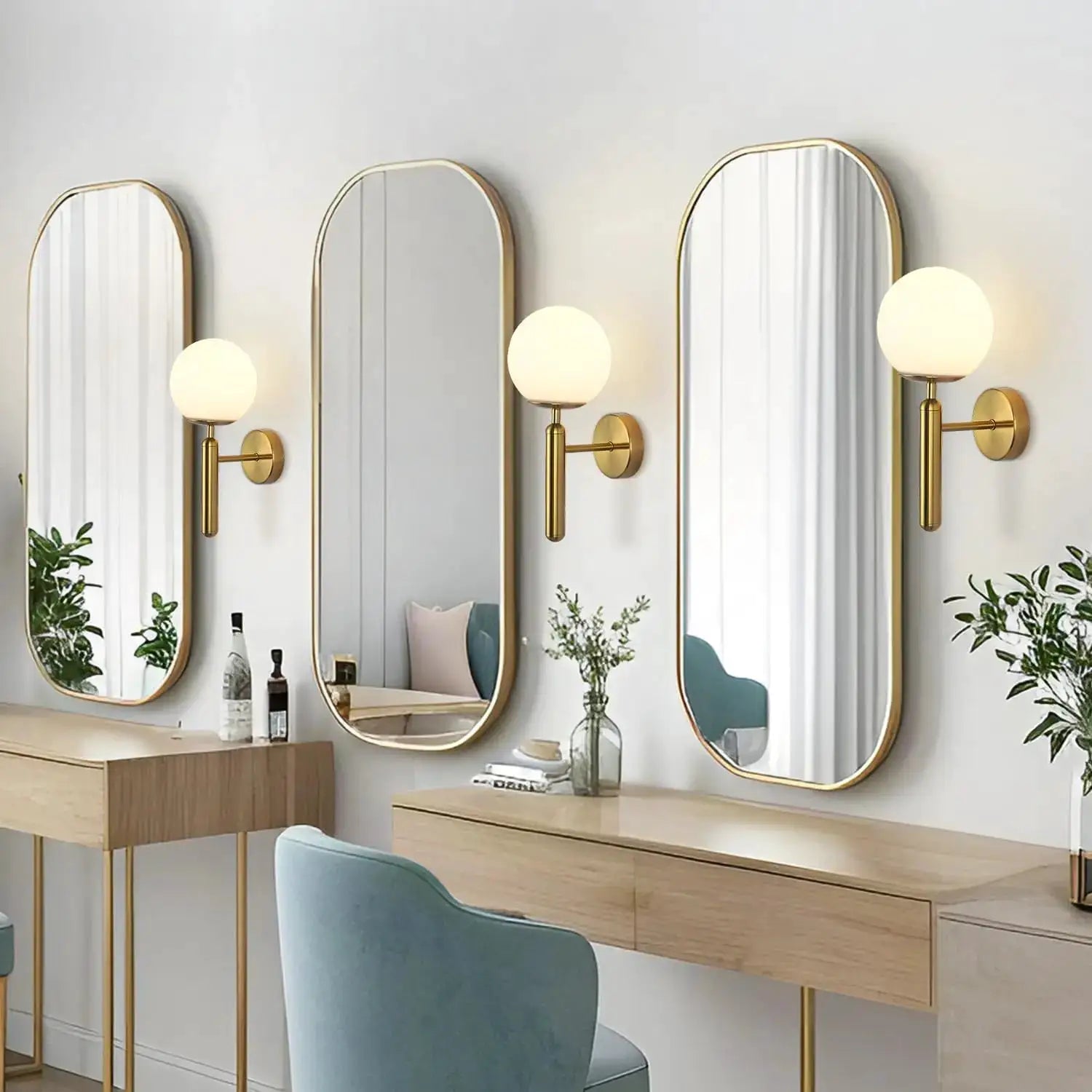 Modern wall light fixtures by Simples Market, brass finish with frosted globe, set of 3 beside arched mirrors