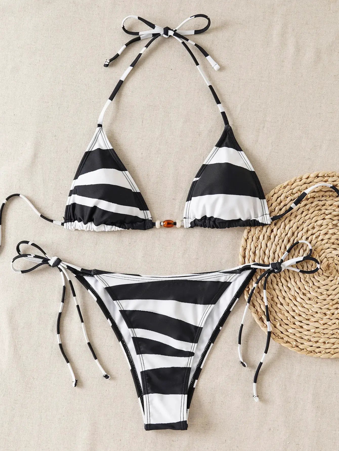 Women's two-piece bikini set in black-and-white zebra stripes with adjustable halter top and tie-side bottoms.