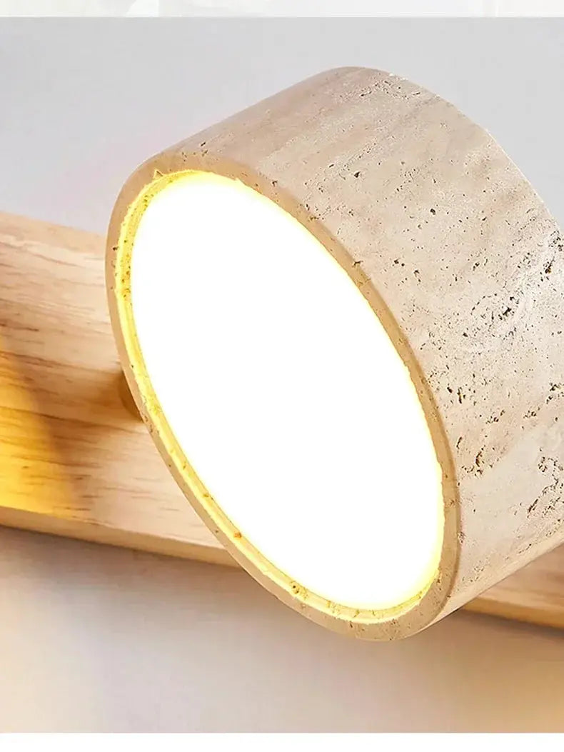 Round LED wall light with a concrete-textured bezel mounted on wood, warm glow.