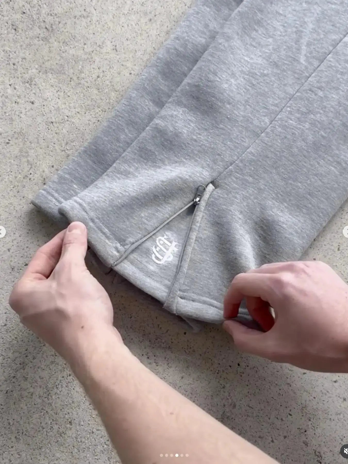 Gray Y2K jogger pants with zippered leg opening and embroidery, casual hip-hop streetwear.