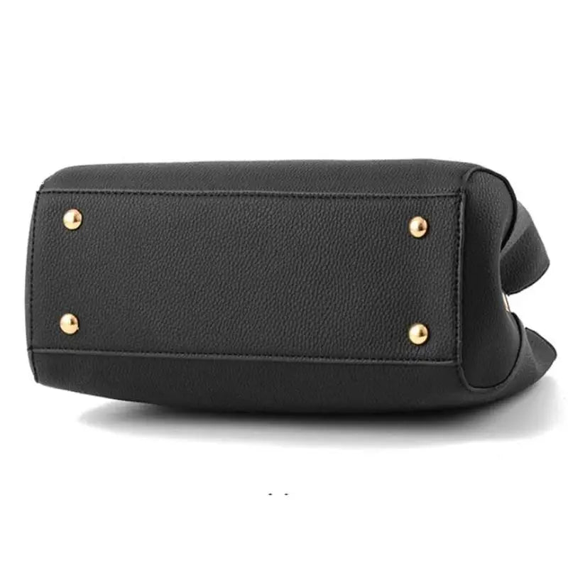 Black leather crossbody handbag with gold-tone studs on the bottom.