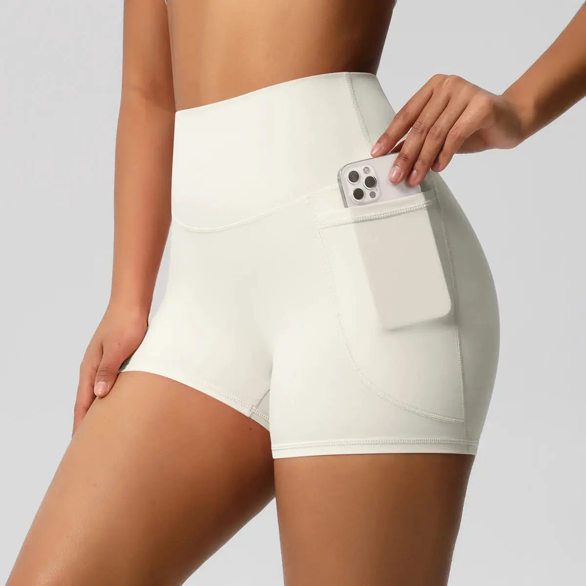 Women’s white high‑waist sport shorts with a side phone pocket for gym workouts.