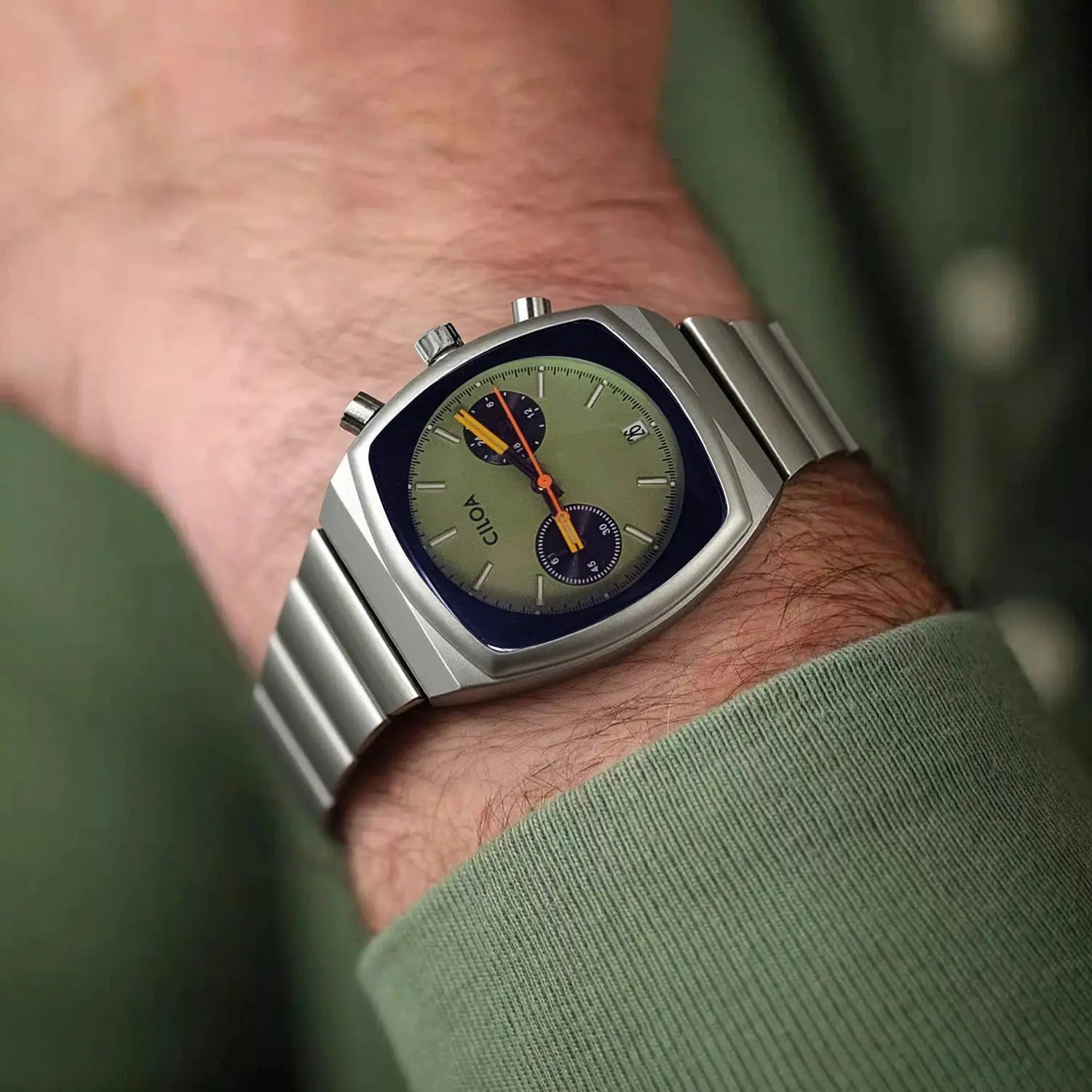 CILOA men's stainless steel quartz watch on wrist with olive dial, orange hands, and date window