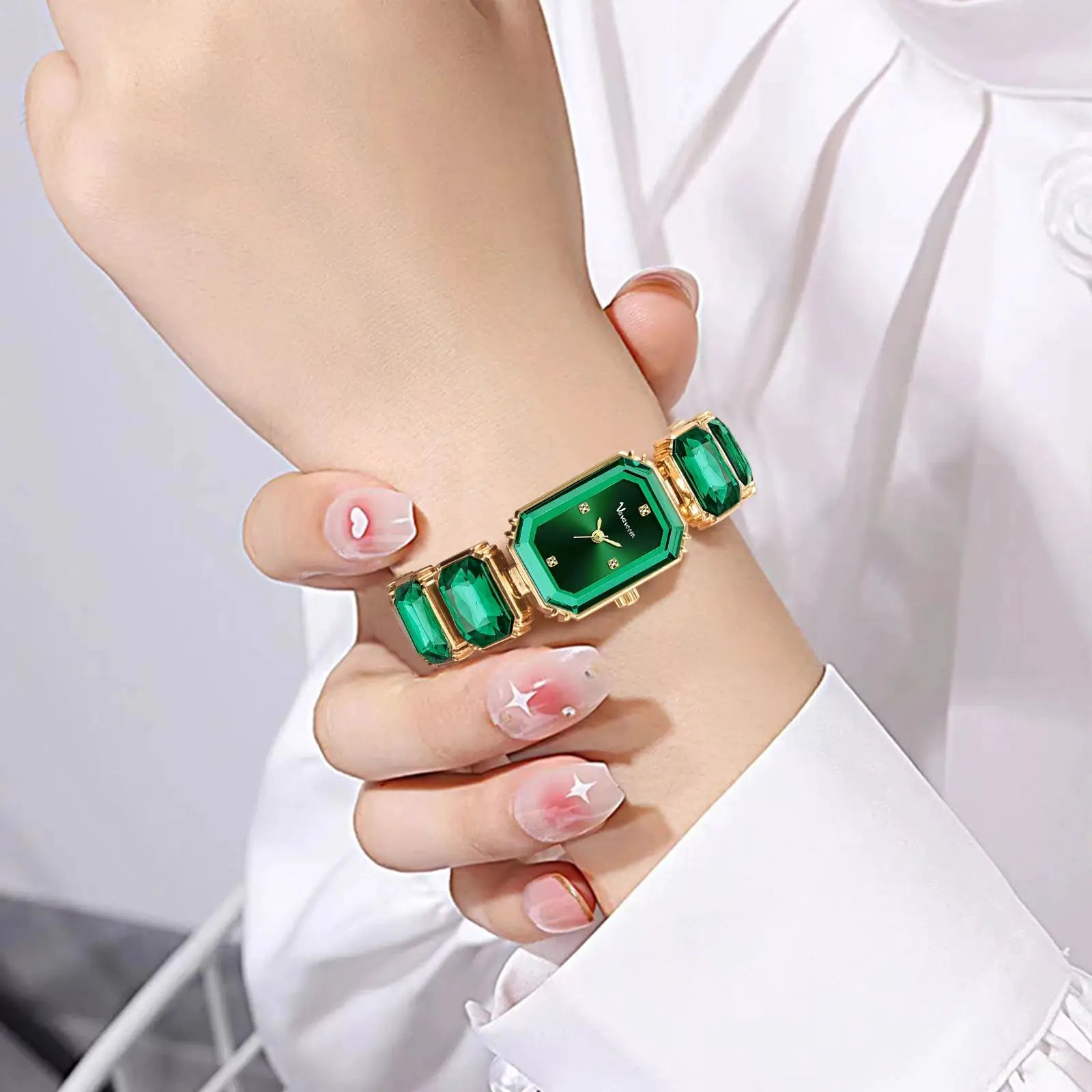 Women square watch with emerald green dial, quartz movement, green gemstone links on rose-gold bracelet.