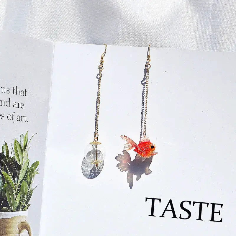 Goldfish drop earrings by Simples Market; transparent globe pendants and red koi fish pendants on gold-tone chains