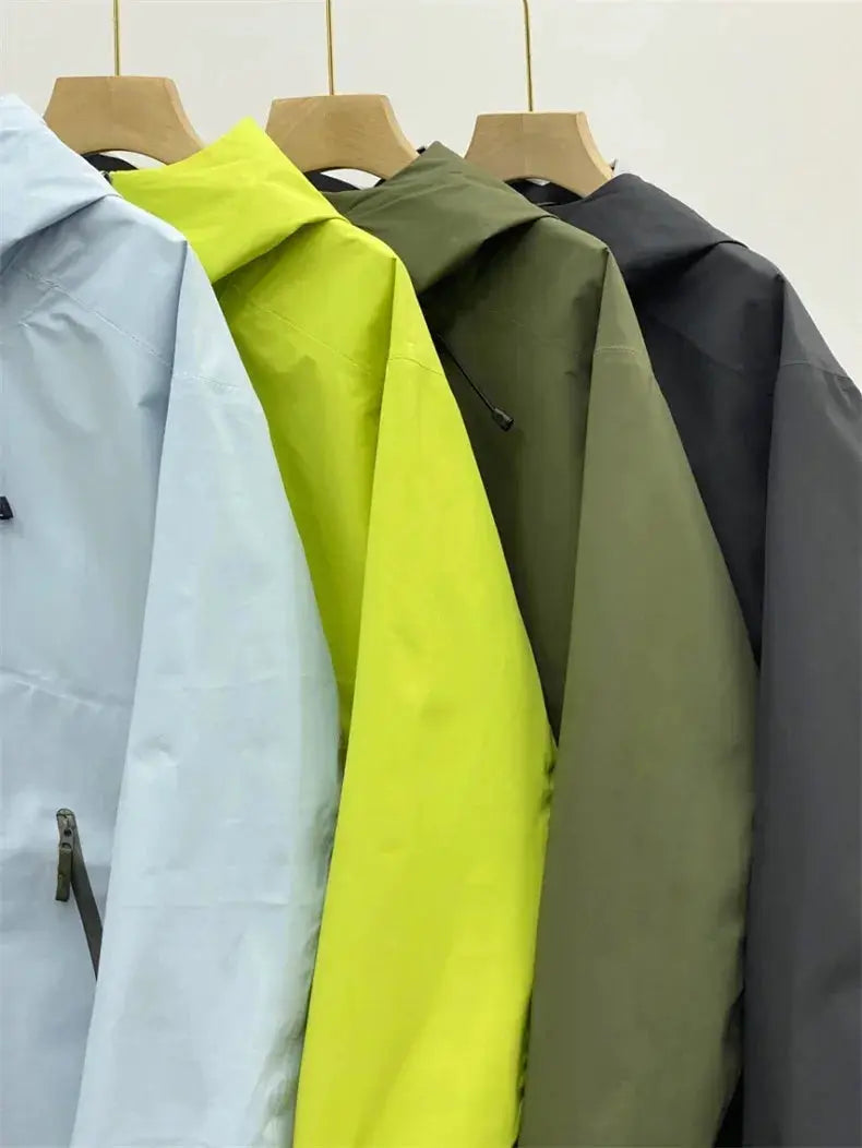 Men's windproof soft-shell outdoor jackets in light blue, neon yellow, olive green and charcoal, on hangers