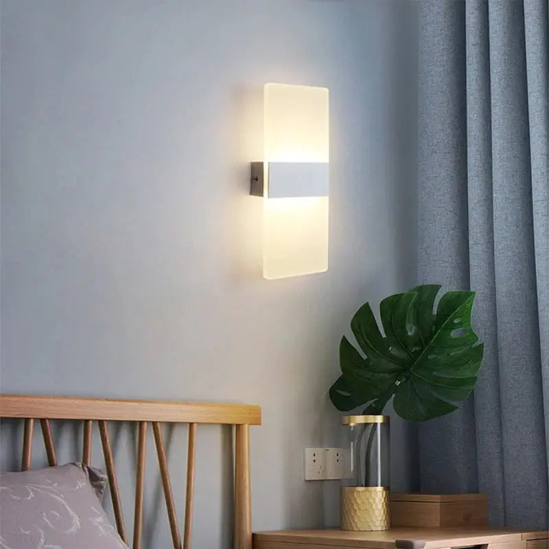 LED acrylic wall light, long rectangular frosted panels with central metal band, warm white glow.