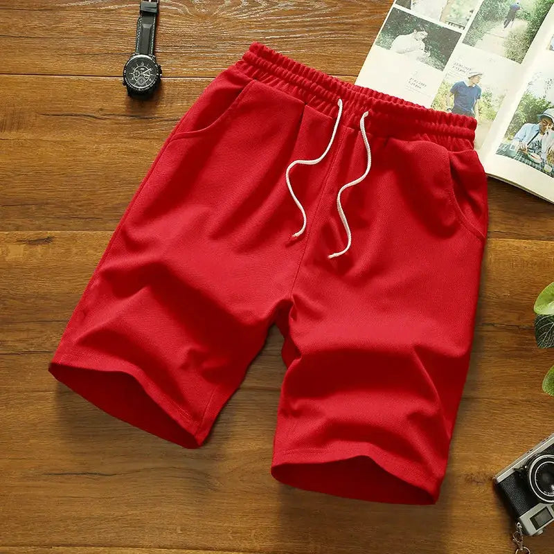 Red men's sports shorts by Simples Market, solid polyester with white drawstring, breathable quick-dry fabric.