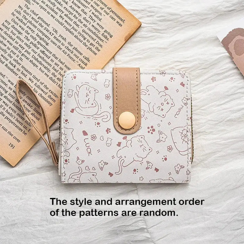 Cat-pattern wallet for women with white background, tan strap closure and gold snap