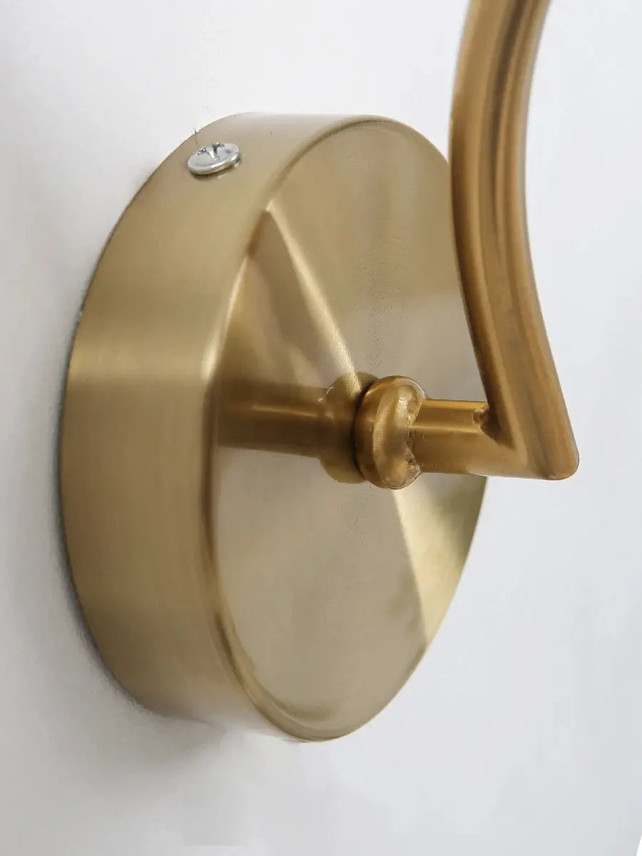 Modern LED wall lamp with brass-gold finish, circular wall mount and curved arm