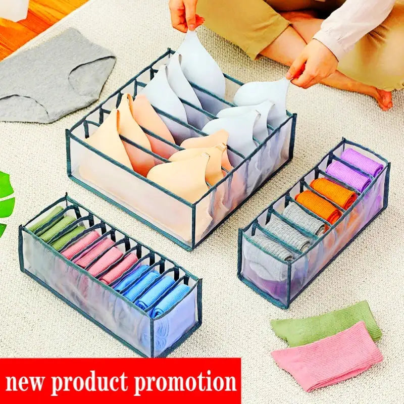 Underwear and sock organizer boxes with fabric dividers; three blue-framed boxes with pastel compartments.