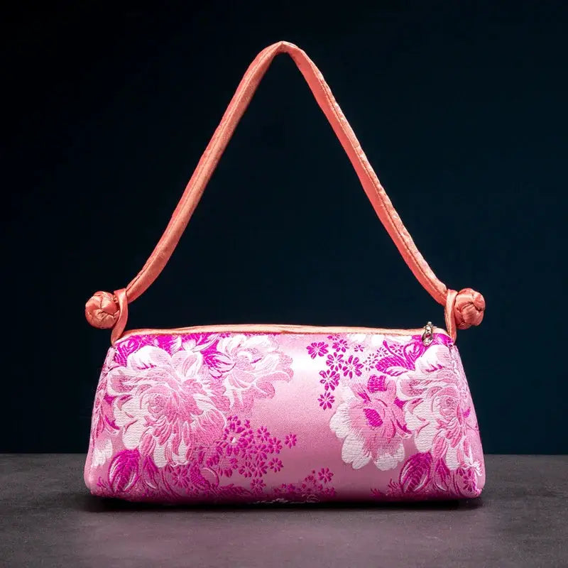 Pink satin shoulder bag with purple floral embroidery by Simples Market