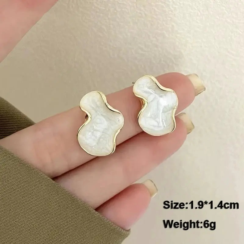 Simples Market white acrylic enamel dangle earrings with irregular pearl-like petals and gold trim, pair