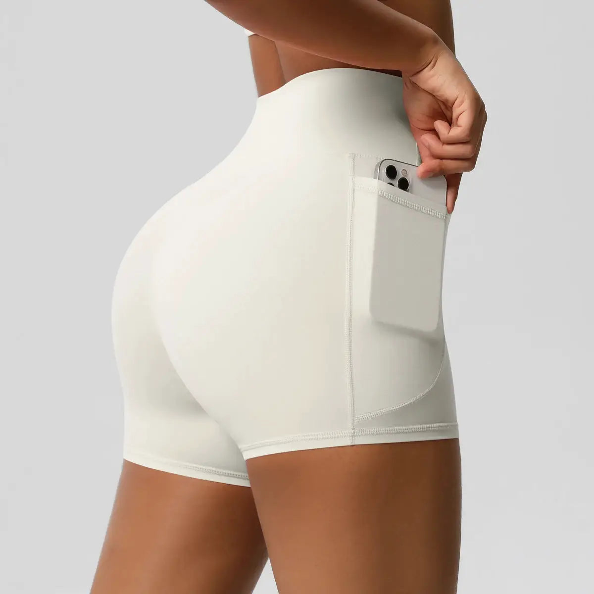 Simples Market women's high-waist pocketed sport shorts in white; quick-dry, squat-proof with side pocket.