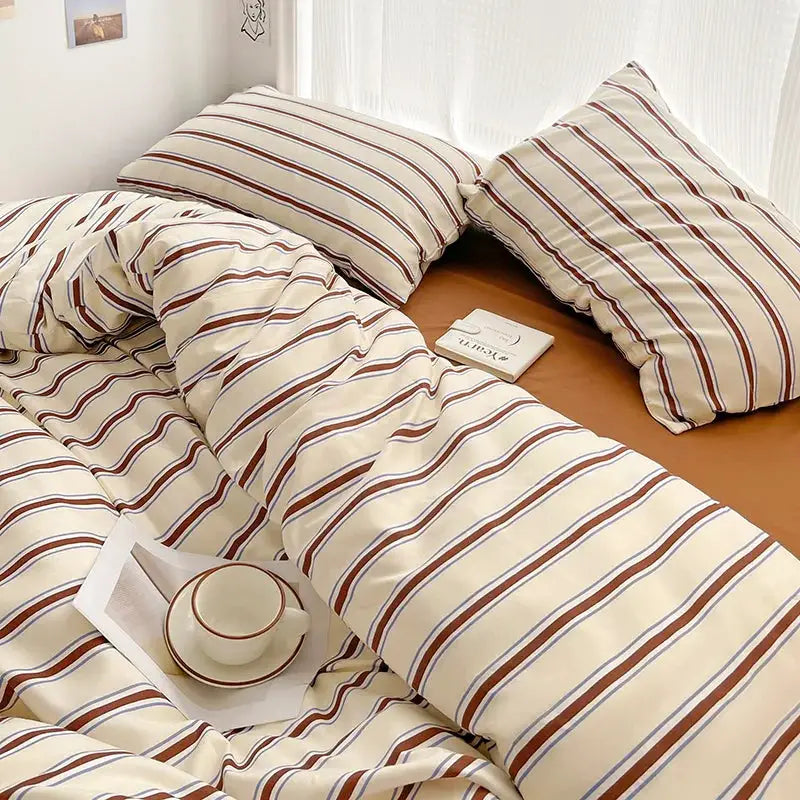 Duvet cover and four-piece sheet set by Simples Market in red and blue striped washed cotton bedding on bed
