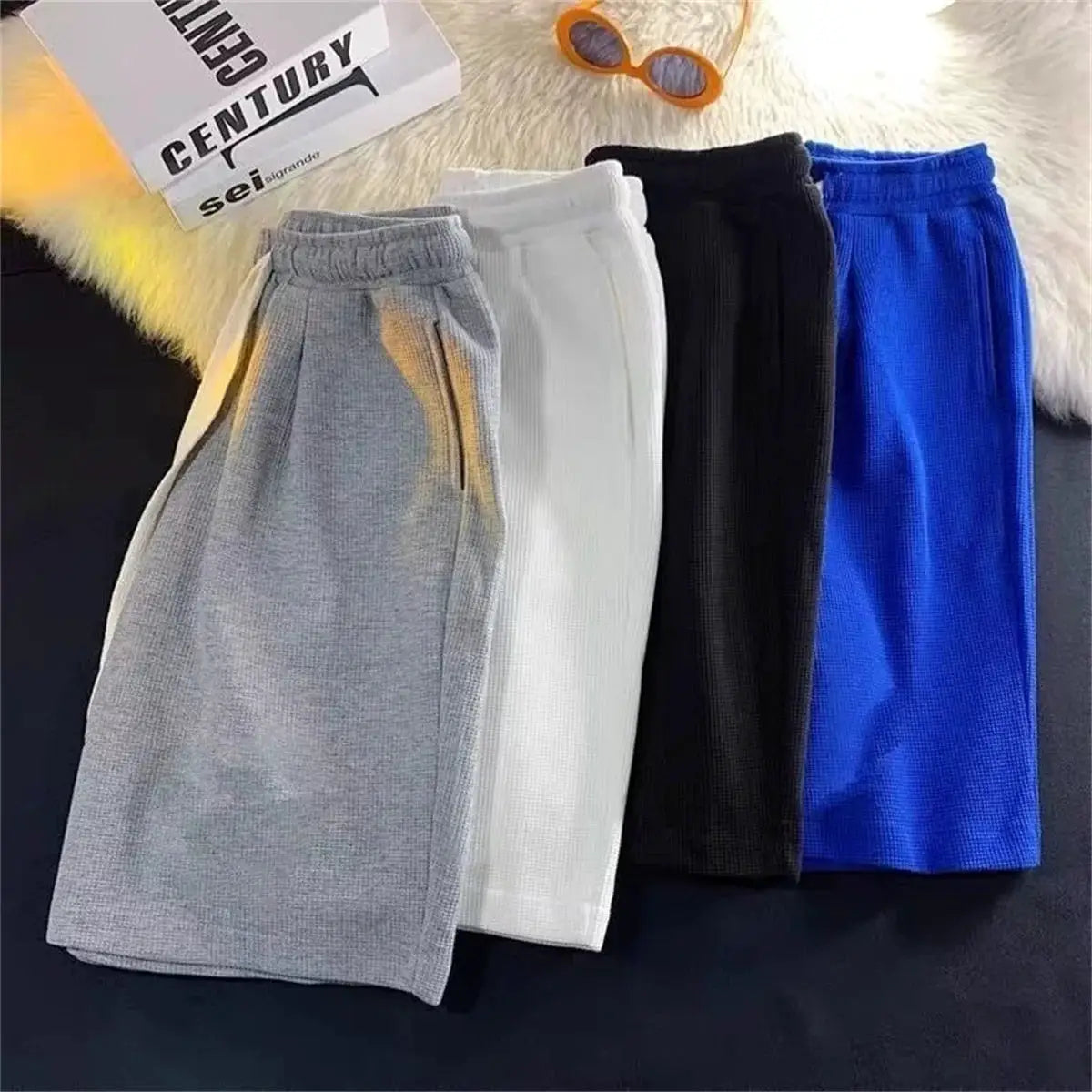Five men's solid breathable athletic shorts in gray, white, black and blue with drawstring waist