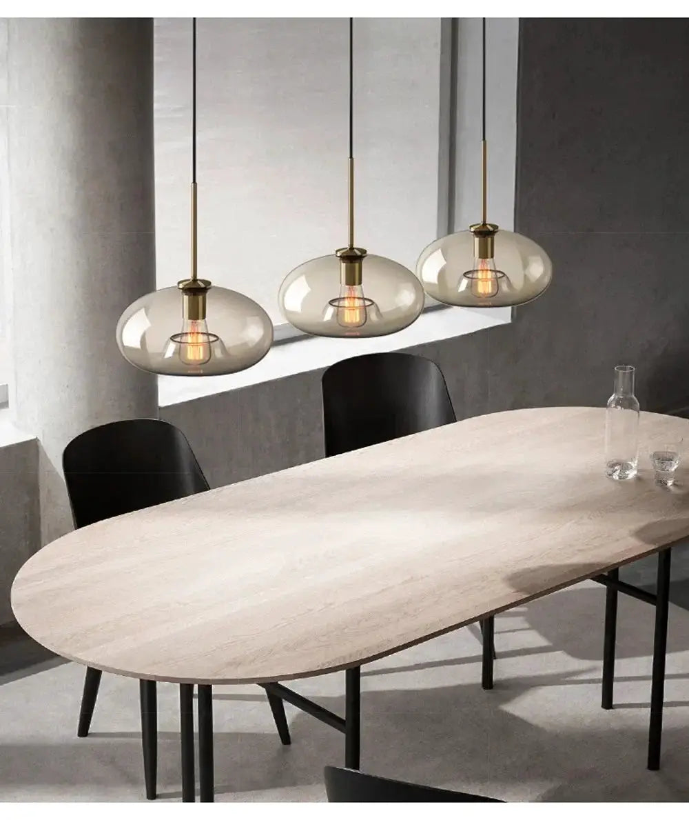 Nordic LED glass pendant chandelier set of 3 with brass fittings hanging over a dining table