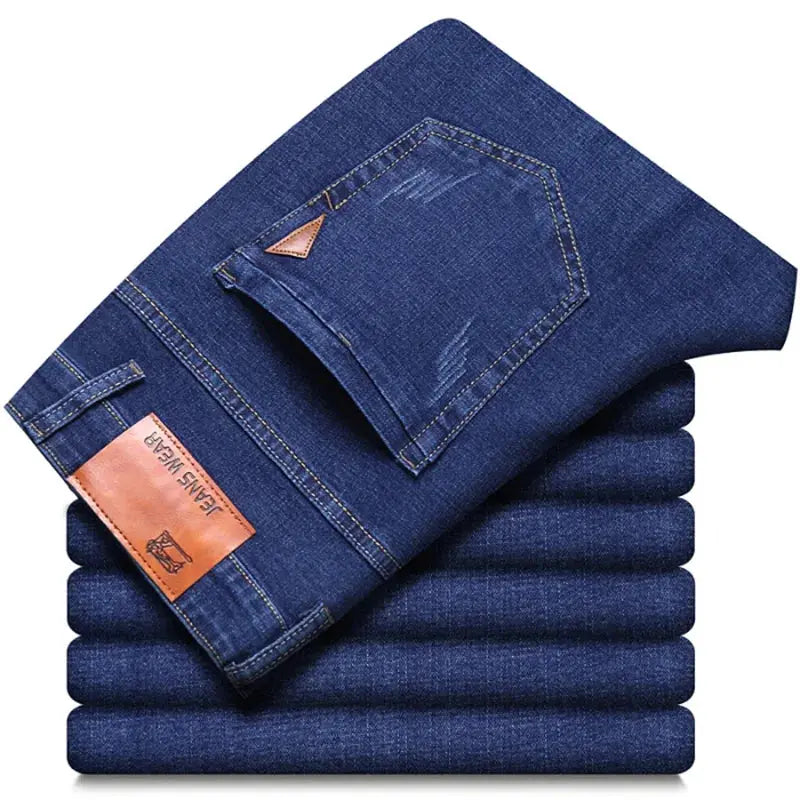 Men's blue denim jeans by Simples Market; stacked, straight-leg, stretch fabric, leather patch.