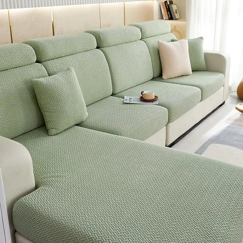Sofa slipcover for sectional couch in sage green jacquard stretch fabric with matching cushions.