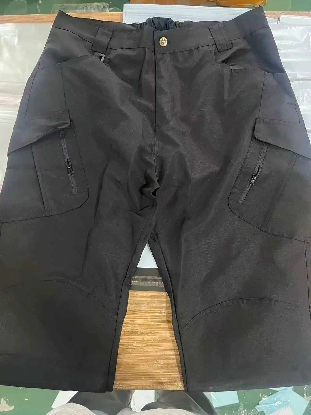 Men's black cargo pants with multiple pockets and zippered side pockets