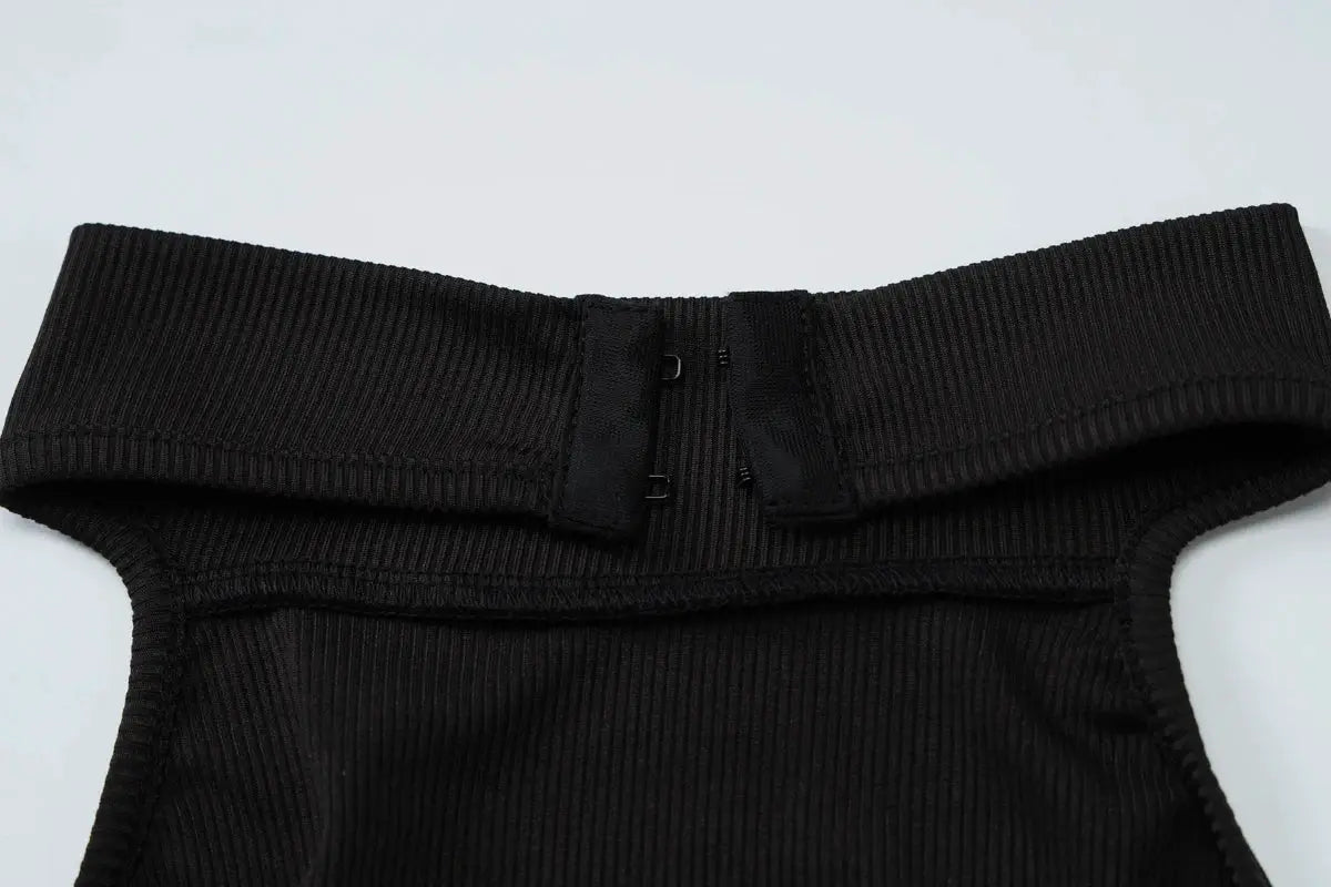 Hugcitar ribbed halter backless jumpsuit in black with button closures.