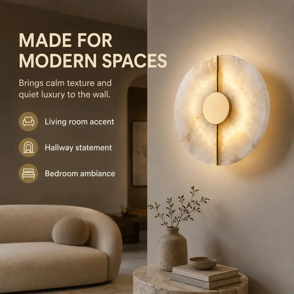 Alabaster marble wall sconce with round disk and gold vertical bar, warm backlit glow.