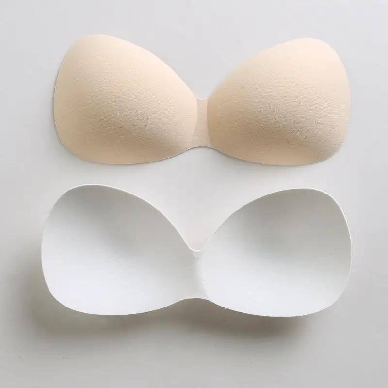 Bra padding inserts by Simples Market; a pair of sponge foam chest pads in beige and white