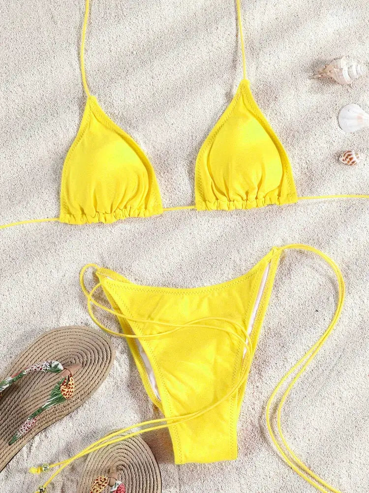 Yellow triangle bikini set with string-tie sides on sandy beach