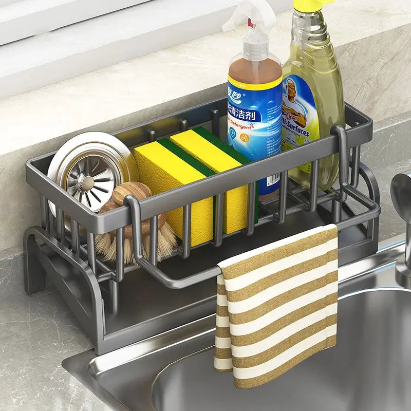 Gray metal kitchen sink drain rack with sponge storage, brushes, soap bottles, and towel bar