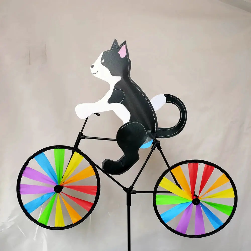 Animal riding wind spinner sculpture of a dog on a bicycle with rainbow wheels for the garden
