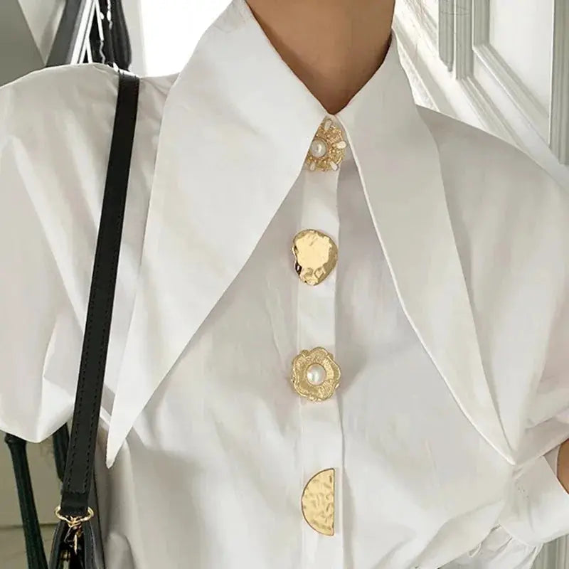 White blouse by Simples Market with oversized sharp-corner collar and pearl-gold buttons, long sleeves